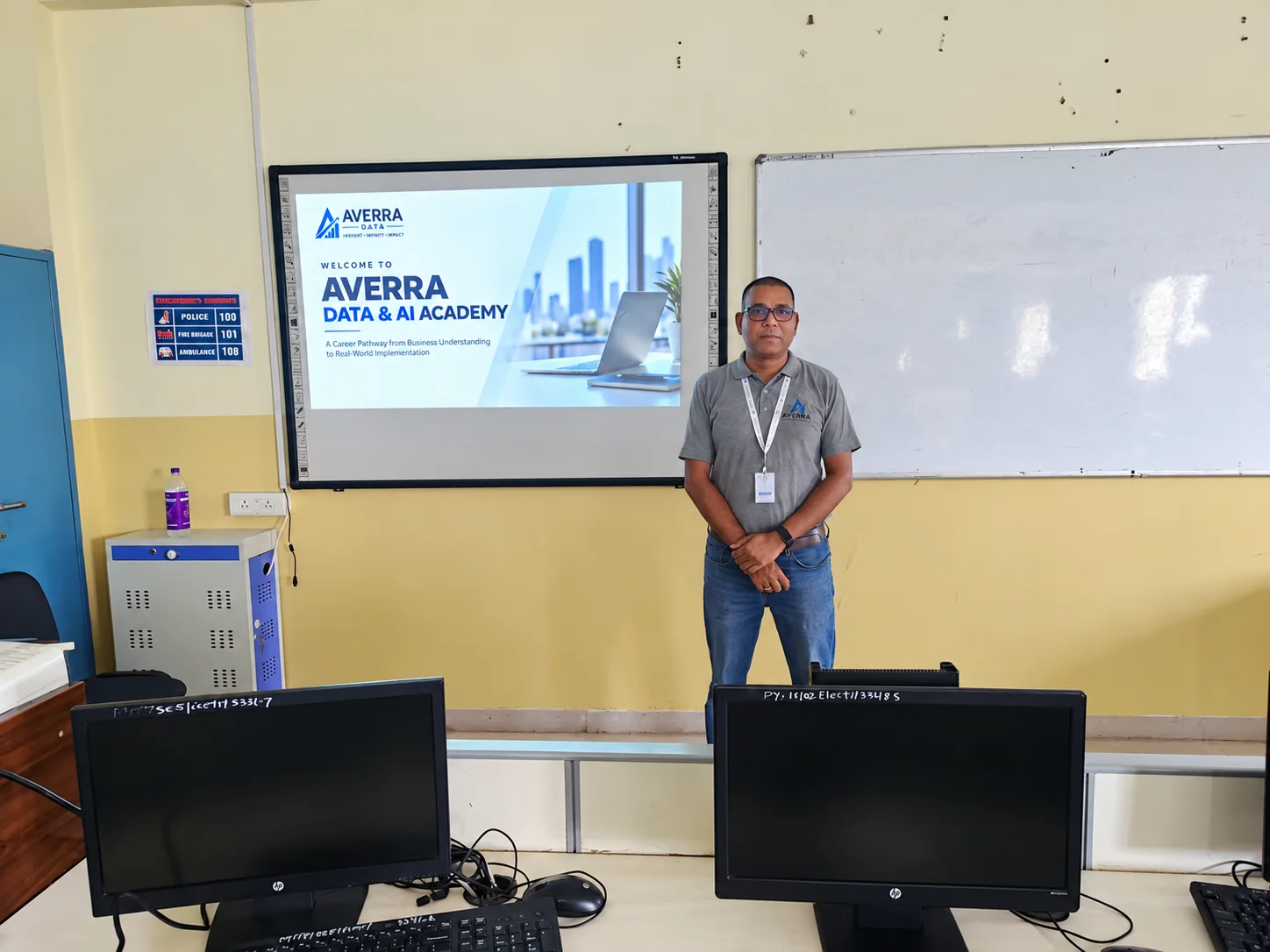 A trainer standing beside a screen that reads Welcome to Averra Data and AI Academy