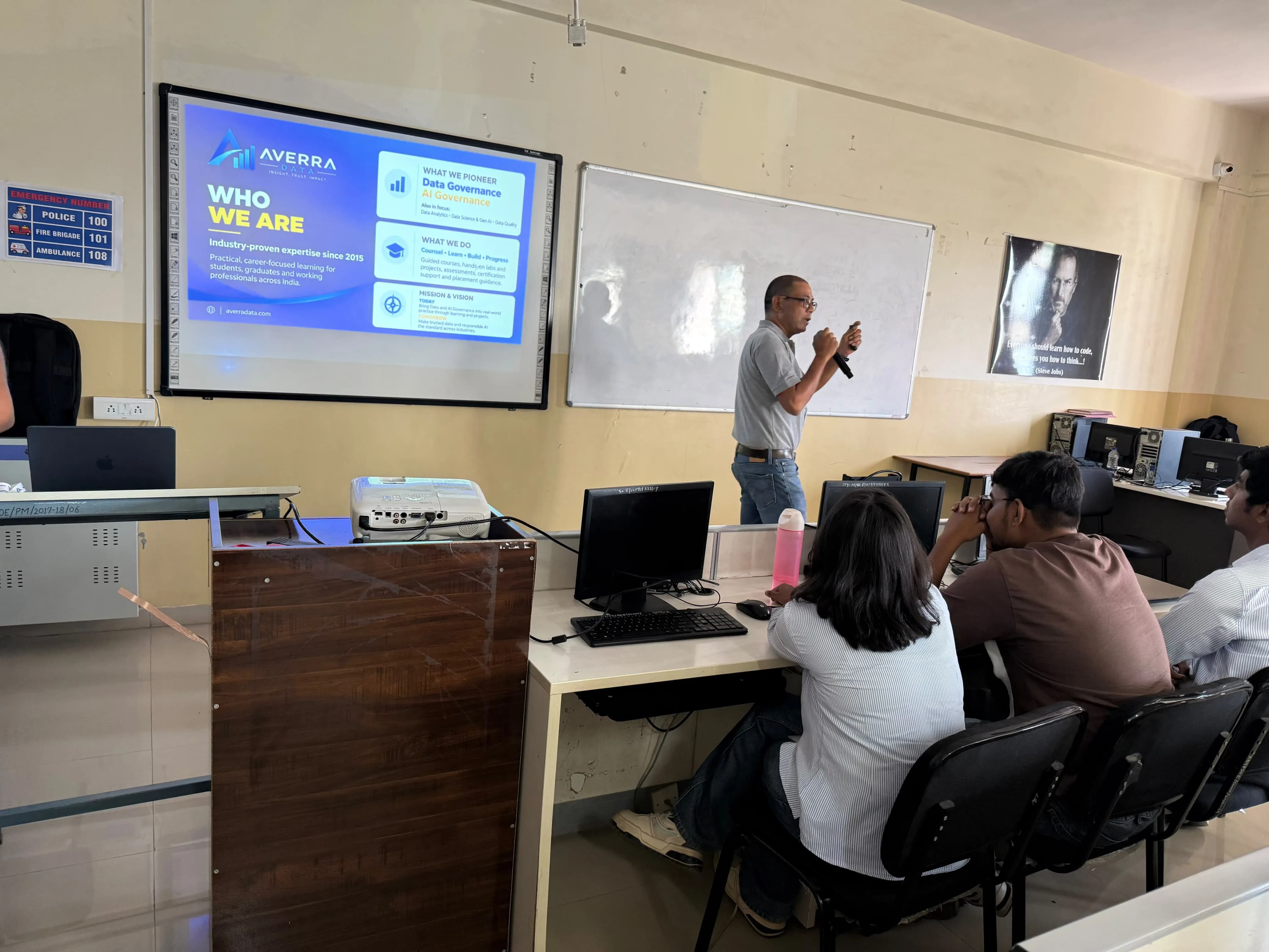 A trainer presenting the Who We Are slide to learners seated at their desks